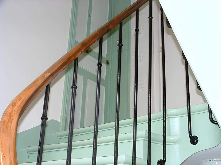 Escalier avec une main courante en bois et des balustres en fer forgé, Île-de-France